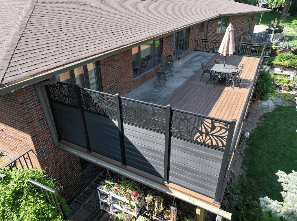 A newly renovated composite deck with rich brown and gray tones featuring black metal railings and decorative privacy panels.