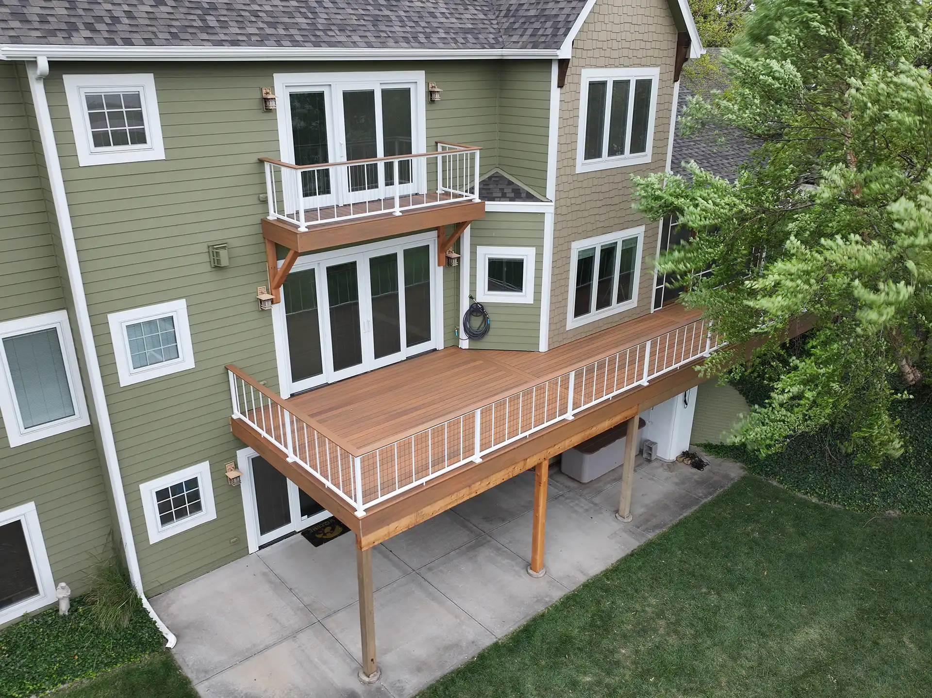 photo of a multi-level deck with concrete patio - Patio Covers Contractor in West Omaha