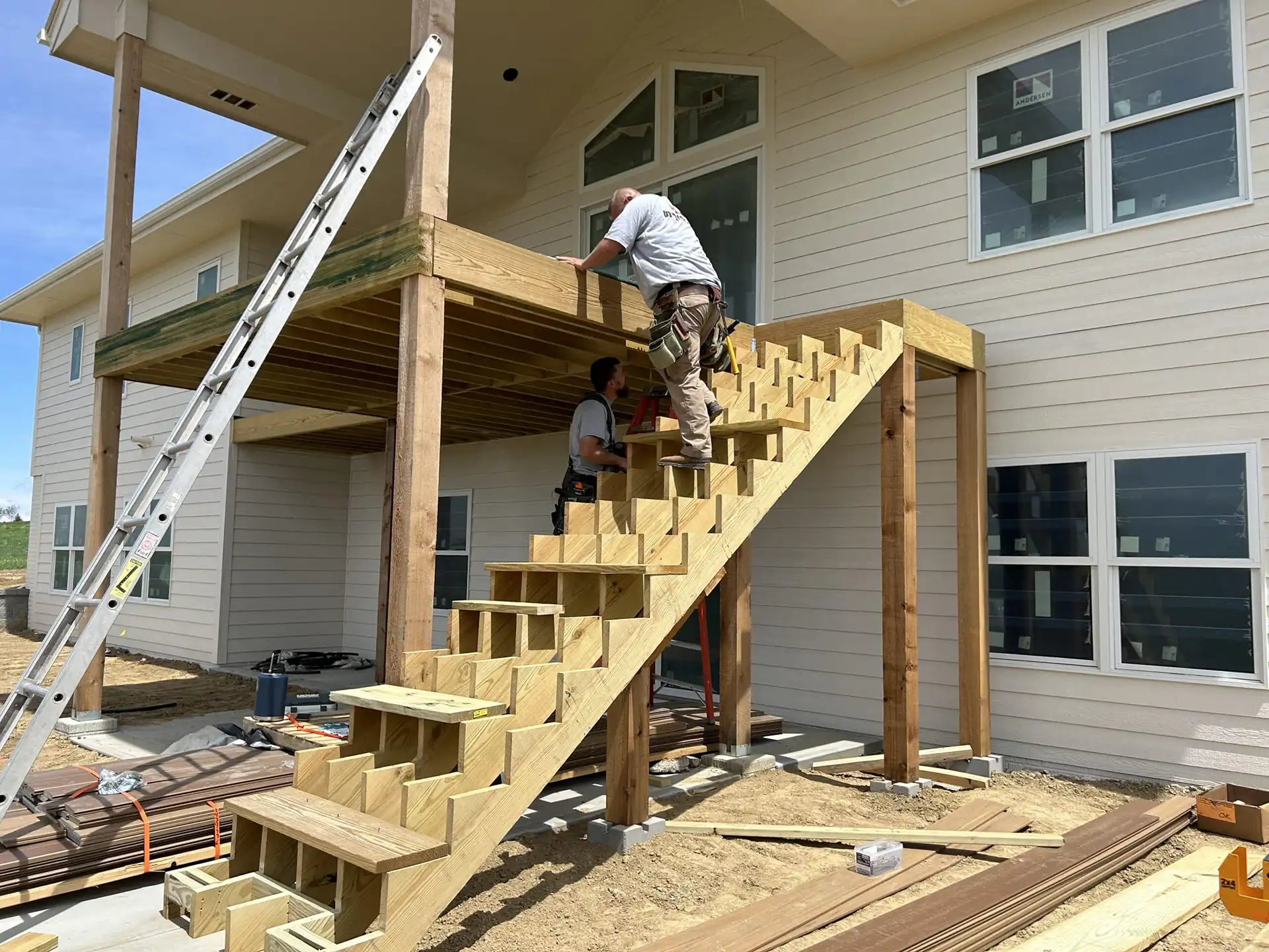 Photo of crews working on one of their large outdoor projects: An elevated deck with steps leading up - Outdoor Projects Contractor in West Omaha