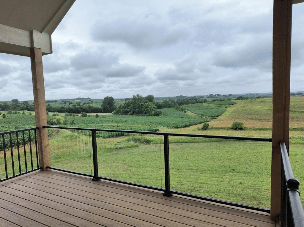 photo-of-an-elevated-deck-with-a-covering-that-deck-railing-and-glass-panels - Glass Deck Railing Systems in west omaha, NE