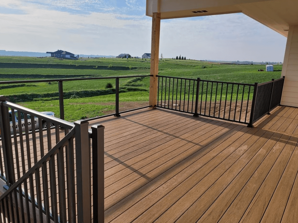 photo of an elevated deck with a section of railing made of glass railing panels - Composite deck with glass railings